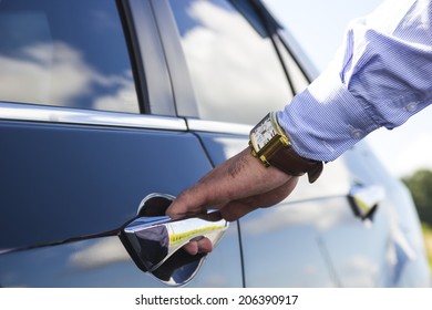 Chauffeur's Hand Opening Passenger Door On Limousine