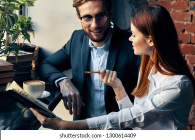 Cheap Man And Woman Are Sitting In A Cafe And Chatting With Each Other Over A Cup Of Coffee