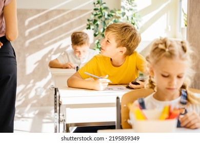 Cheating On The Exam Class Lesson Test. Lazybones Boy Student Pupil In Yellow T-shirt Schoolchildren. Male Student Peeking With Phone During Class Test Attendancy, Academic Performance Concept.