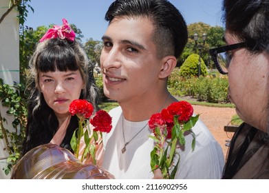 Cheating Young Man On Double Date Outside In Public Park, With Flowers And Balloon Heart Looking At Camera With Nervous Smile, Valentine Concept