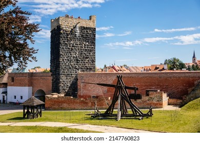 Cheb, Western Bohemia, Czech Republic, 14 August 2021: Gothic stone castle, medieval historic fortress or stronghold in sunny summer day, black Tower, ballista wooden siege weapons near defense walls