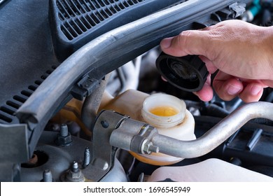 Check brake fluid,Hand open a tank for car maintenance. - Shutterstock ID 1696545949