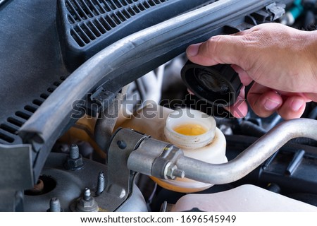 Check brake fluid,Hand open a tank for car maintenance.