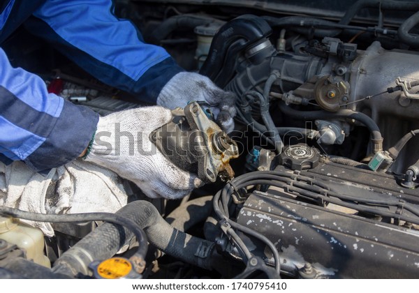 Check engine\
ignition system and change ignition coil. Car care\
service.\
Replacing ignition coil and spark plugs.\
Car mechanic\
fixing ignition coil on gasoline\
engine.