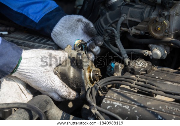 Check engine ignition system and change ignition\
coil. Car care service.\
Replacing ignition coil and spark\
plugs.\
Car mechanic fixing ignition coil on gasoline, cylinder\
combustion engine.