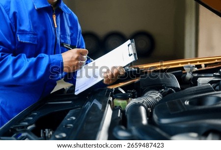Check and inspect the condition of the car engine in detail. The mechanic is writing on a clipboard while looking at the car engine to assess the car's repair and maintenance.