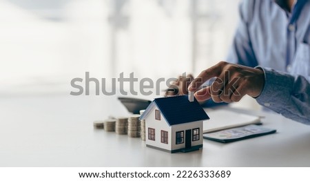 Check list before buying a new home to meet the bank criteria. Close-up shot of silver coin drop and house model Savings by adding your money to the real estate owner in a futuristic concept.