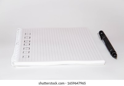 Check list. Square items are empty and checked with a tick. Squared notebook with black pen on a white background. Record ideas, notes, plans, tasks. Copy Space
