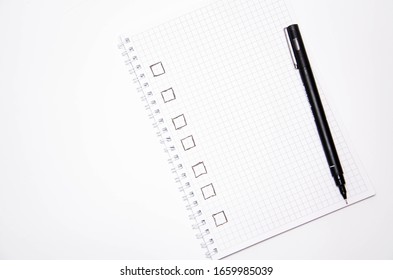 Check list. Square items are empty and checked with a tick. Squared notebook with black pen on a white background. Record ideas, notes, plans, tasks. Copy Space