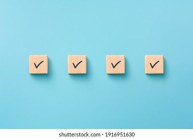 Check mark on wooden blocks, blue background, Checklist concept