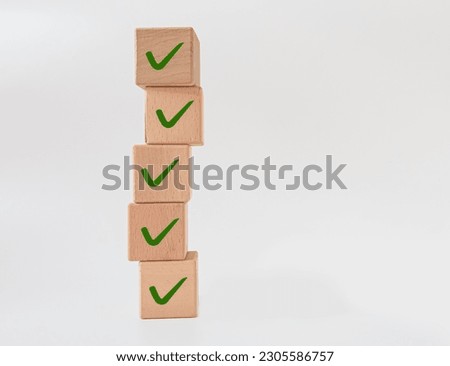 Check mark on wooden blocks.
checklist idea concept.