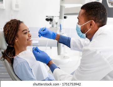 Check Up At Modern Dental Clinic. African Lady Smiling To Doctor At Dentist Chair