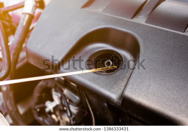 Check the oil level in car engine. Mechanic\
checking car engine