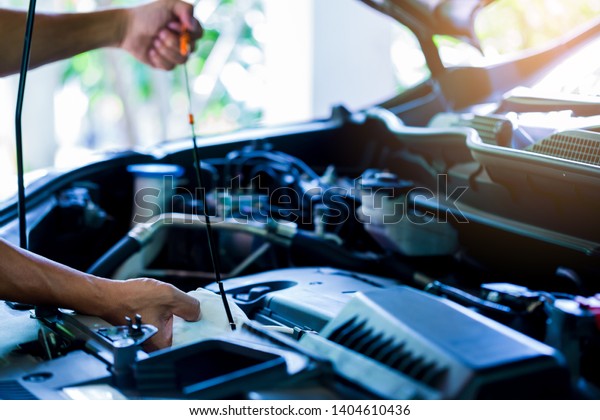 Check the oil level in car engine.\
Mechanic checking car engine or vehicle. Check and maintenance car\
with yourself. Service and maintenance\
vehicle.