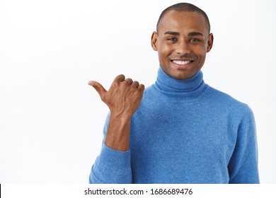 Check Out My New Car, Its Outside. Portrait Of Pleased, Proud Smiling African American Male Pointing Thumb Left And Grinning Satisfied, Showing Banner, Promo Of Company Or Service, White Background