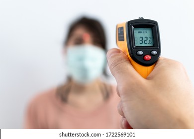 Check temperature for disease with contactless thermometer. Temperature control preventing spread of virus pandemic. Covid-19, Coronavirus measure to control diffusion. White background blurred figure - Powered by Shutterstock