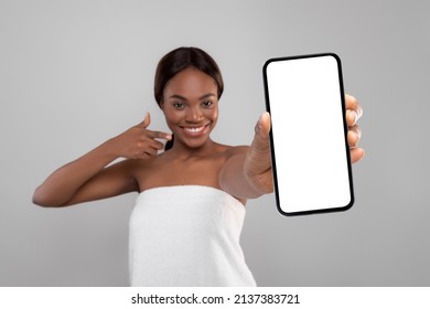 Check This App. Beautiful Young Black Female Wrapped In Bath Towel Demonstrating Big Blank Smartphone At Camera And Pointing At It, Happy Woman Advertising New Beauty Application, Collage, Mockup