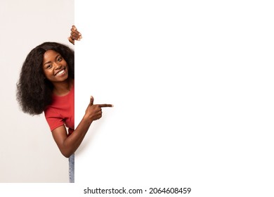 Check This. Smiling African American Lady Pointing Aside At Copy Space On Blank White Advertisement Board With Finger, Positive Black Woman Showing Free Place For Your Design On Empty Billboard - Shutterstock ID 2064608459