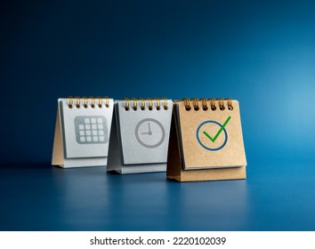 Checked icon, Time and date symbol on three desk calendar covers standing isolated on blue background, minimal style. Reminder, schedule planning, agenda, and action plan concepts. - Shutterstock ID 2220102039