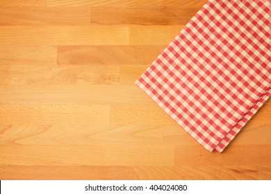 Checked Tablecloth On Wooden Kitchen Counter. View From Above