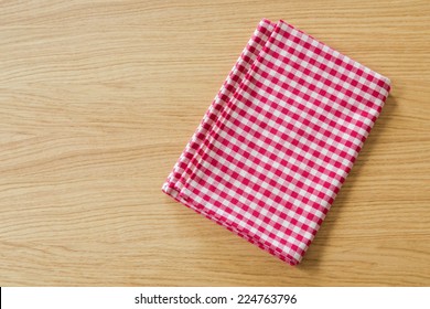 Checked Tablecloth On Wooden Table. View From Above With Copy Space