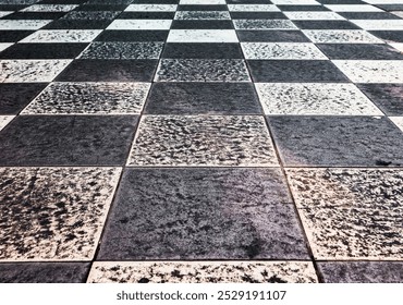 Checkerboard pattern surface, black and white. Grainy asphalt road surface and has a rough texture. Close- up, top view, full frame.