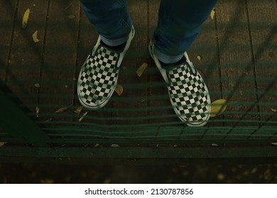 Checkerboard Shoes Visible From The Iron Fence