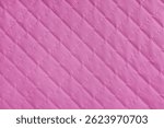 Checkered, diamond stitching pattern, pink quilted fabric background. Blanket or puffer jacket, stitch rhombus texture close up, macro. Wallpaper, backdrop.