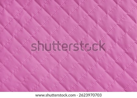 Checkered, diamond stitching pattern, pink quilted fabric background. Blanket or puffer jacket, stitch rhombus texture close up, macro. Wallpaper, backdrop.