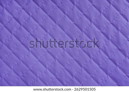 Checkered, diamond stitching pattern, purple quilted fabric background. Blanket or puffer jacket, stitch rhombus texture close up, macro. Wallpaper, backdrop.