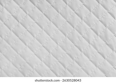 Checkered, diamond stitching pattern, white quilted fabric background. Blanket or puffer jacket, stitch rhombus texture close up, macro. Wallpaper, backdrop.
