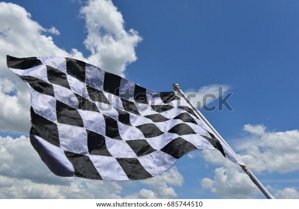 Checkered flag for\
the winner on the blue\
sky