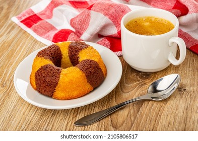 Checkered Napkin, Bicolor Muffin In Shape Ring In White Glass Saucer, Spoon, Cup With Coffee Espresso On Wooden Table