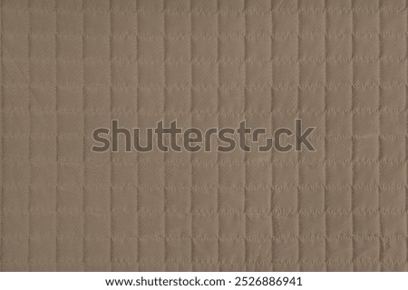 Checkered stitching pattern, brown quilted fabric background. Blanket or puffer jacket, stitch square texture close up, macro. Wallpaper, backdrop.