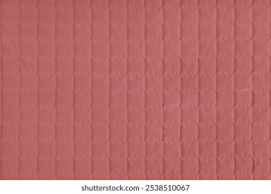 Checkered stitching pattern, red quilted fabric background. Blanket or puffer jacket, stitch square texture close up, macro. Wallpaper, backdrop.
