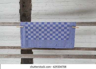 A checkered tea towel which is drying on a clothes line