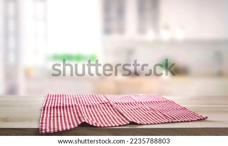 Checkered towel on wooden table. Food design layout. T
Picnic towel on kitchen tabletop.