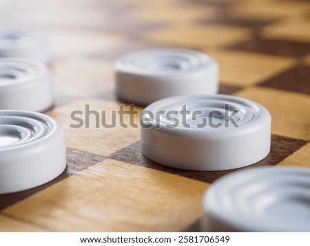 Checkers game setup on a checkered board. Strategy, game pieces, black and red, ready to play, board game, close up.