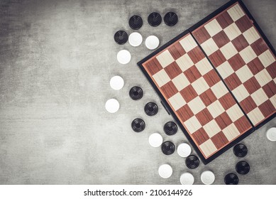 Checkers are scattered near the chessboard, top view. Mind games, mental development and strategy. Games for children and adults. Chess school. - Shutterstock ID 2106144926