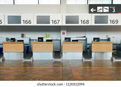 Check-in Counters Area At International Airport Vienna Austria. A Lineup Of Check-in Counters With Black LCD Screen.