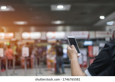 Checkin Online Or Booking By Smartphone Concept: Hands Using Smart Phone Apps In Airport ForCheck In Through Mobile Application, Traveler At Airport Departure Lounge Travel In Airplane 