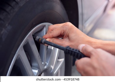 Checking Air Pressure And Refilling Air Into Car Tire At Petrol Station.