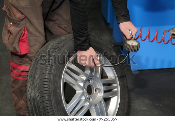 Checking\
the air pressure in a tire with a pressure\
gauge