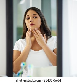 Checking For Any Spots. Shot Of An Attractive Young Woman Getting Ready In Her Bathroom.