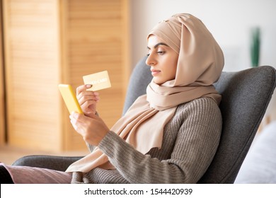 Checking Balance. Beautiful Woman Wearing Pink Hijab Using Phone For Checking The Balance Of Bank Account