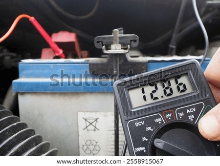 Checking battery charge levels with a voltmeter. Measuring car battery voltage.