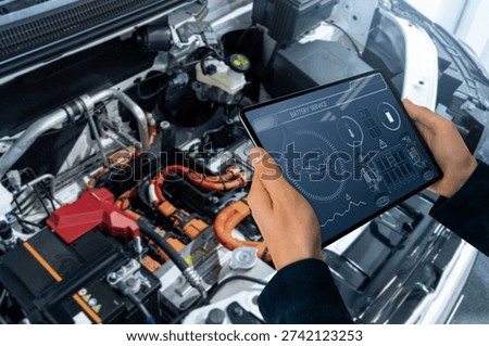 Checking the battery pack of an electric car at a service center.