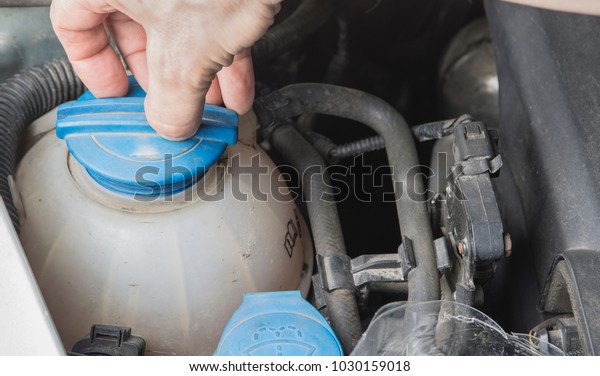 Checking\
car radiator coolant level and add up\
liqiud.