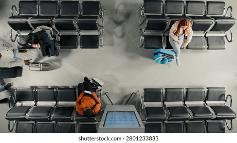 Checking departure board, timetable and top-down view of people walking in airport terminal, reading airplane schedule.