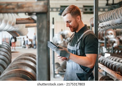 Checking details. Man in uniform is in workstation developing details of agriculture technique. - Shutterstock ID 2175317803